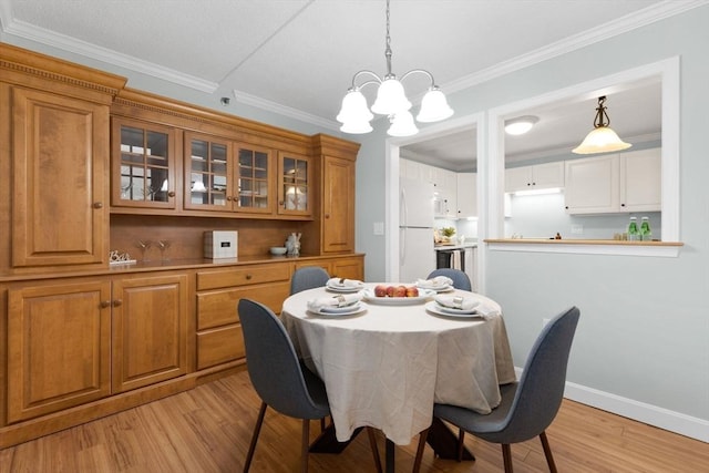 dining space featuring baseboards, a notable chandelier, light wood-style flooring, and crown molding