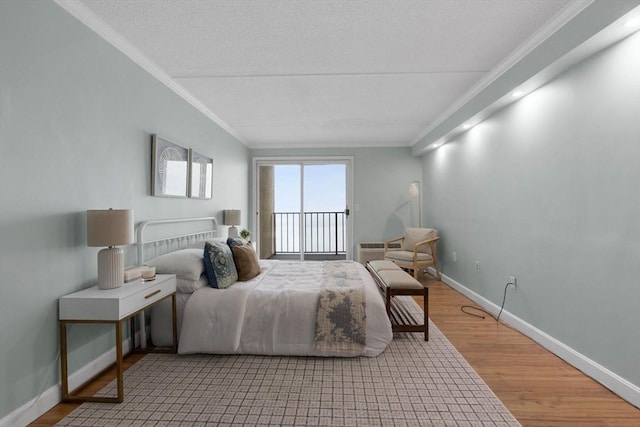bedroom with crown molding, wood finished floors, baseboards, and access to exterior