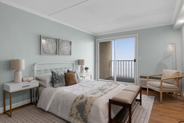 bedroom with wood finished floors, a textured ceiling, baseboards, access to outside, and ornamental molding