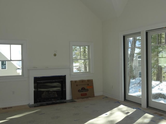 unfurnished living room featuring plenty of natural light and vaulted ceiling