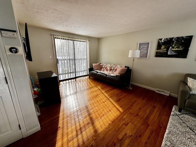 living room featuring a textured ceiling and dark hardwood / wood-style floors