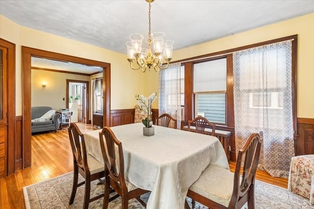 13 Conwell Ave, Somerville, MA 02144 - dining area featuring an inviting chandelier, light wood-type flooring, a wealth of natural light, and a wainscoted wall
