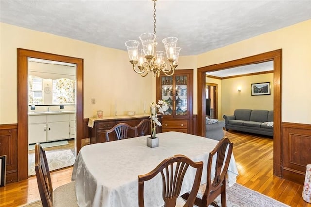 13 Conwell Ave, Somerville, MA 02144 - dining space with wainscoting, wood finished floors, and a notable chandelier