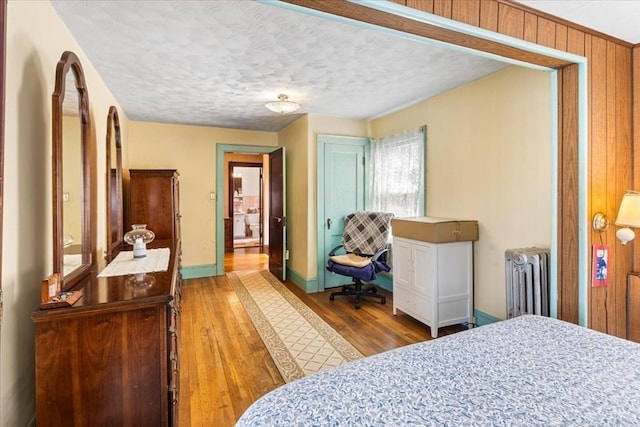 13 Conwell Ave, Somerville, MA 02144 - bedroom with wood finished floors, baseboards, a textured ceiling, and radiator heating unit
