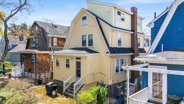 13 Conwell Ave, Somerville, MA 02144 - rear view of house with roof with shingles, fence, entry steps, and a gambrel roof