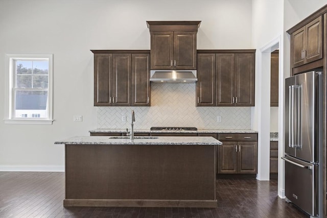 kitchen featuring stainless steel appliances, sink, a kitchen island with sink, and dark brown cabinets