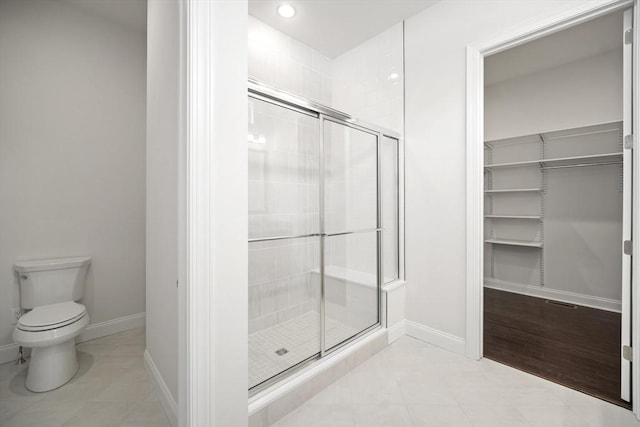 bathroom with an enclosed shower and toilet