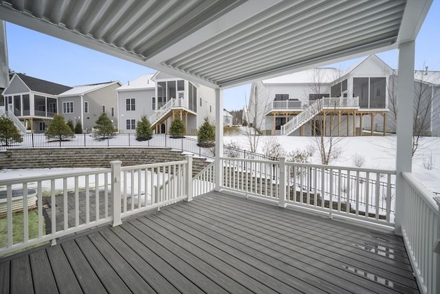 snow covered deck with a sunroom