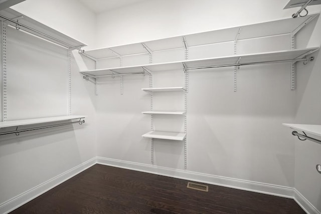 spacious closet with dark hardwood / wood-style floors