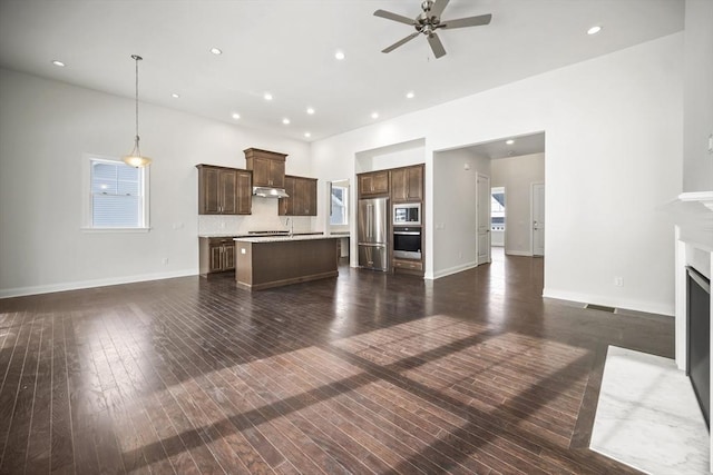 unfurnished living room with dark hardwood / wood-style flooring and ceiling fan