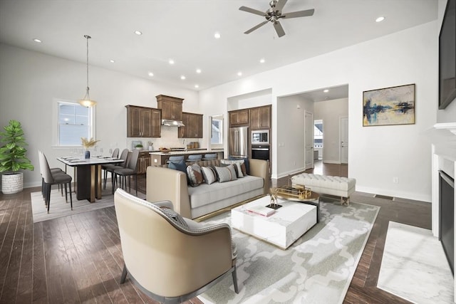 living room featuring ceiling fan and dark hardwood / wood-style floors