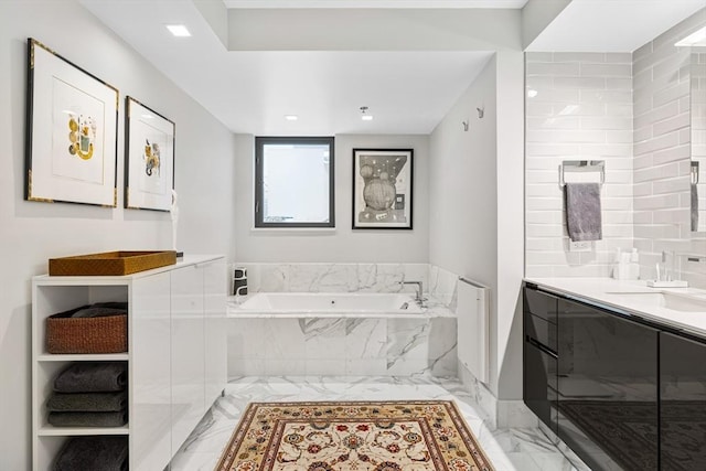 bathroom featuring vanity, marble finish floor, and a bath