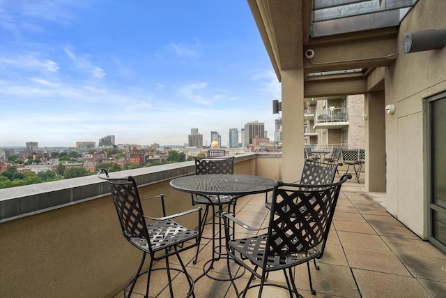 balcony featuring a view of city and outdoor dining area