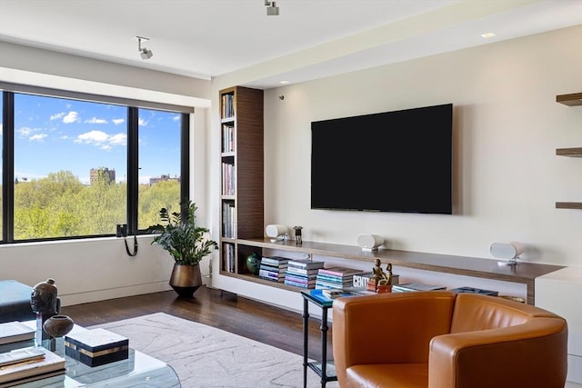 living area with baseboards and wood finished floors