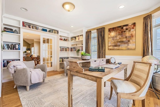 office area featuring built in shelves, ornamental molding, and light wood-style flooring