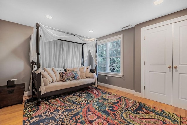 living area with light wood-type flooring, visible vents, baseboards, and recessed lighting