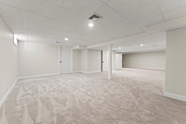 basement featuring carpet flooring and a drop ceiling