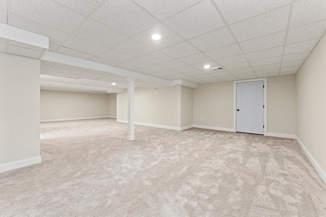 basement with a drop ceiling and light colored carpet