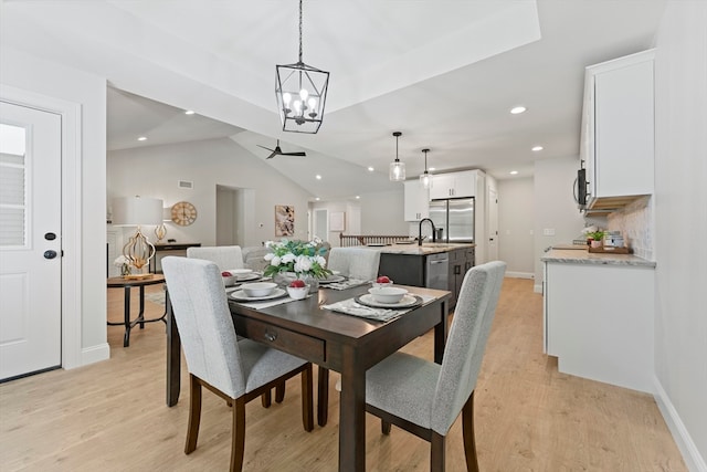 dining space featuring light hardwood / wood-style flooring, lofted ceiling, and a chandelier