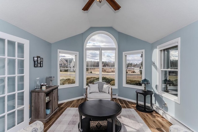 sitting room with lofted ceiling, a baseboard heating unit, dark wood-type flooring, and ceiling fan