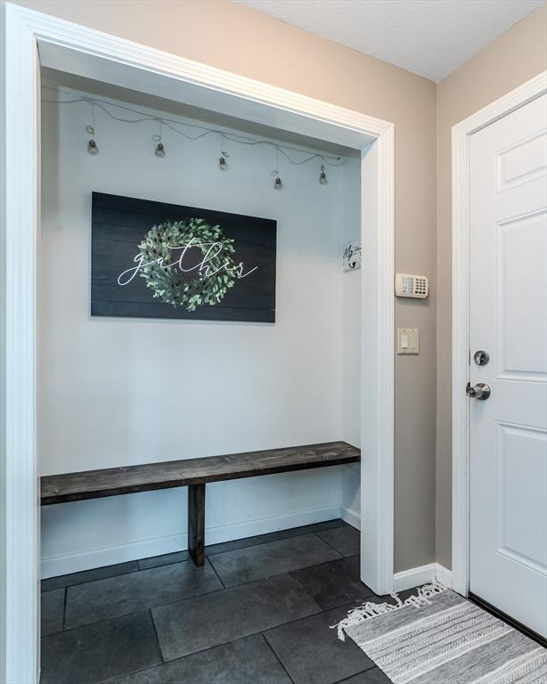 mudroom with dark tile patterned floors