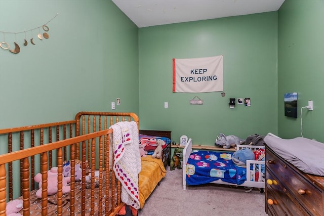 bedroom featuring a crib and carpet flooring