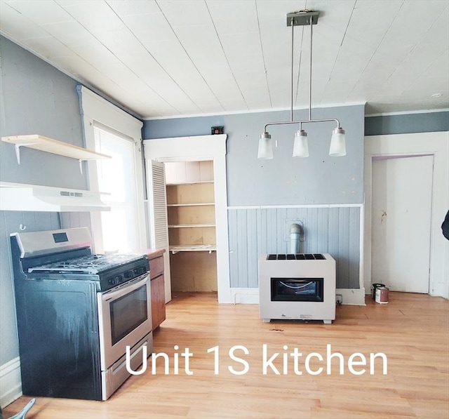 kitchen featuring under cabinet range hood, gas range, a wood stove, heating unit, and open shelves