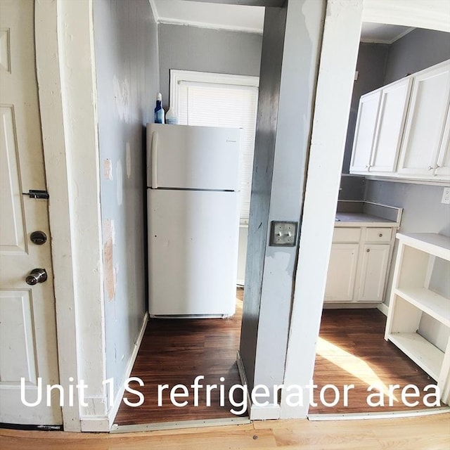 kitchen featuring dark wood-style floors, white cabinetry, and freestanding refrigerator