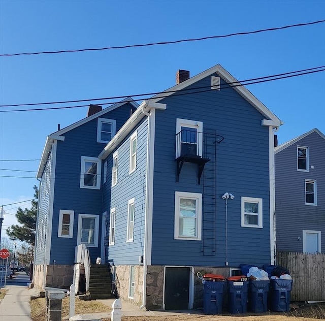 rear view of property with fence and a chimney