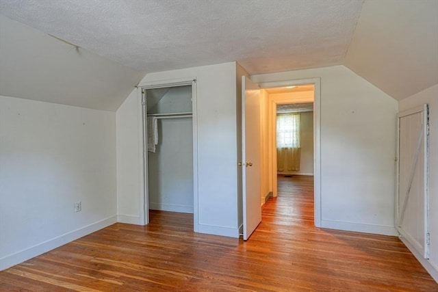 22 Willis Lake Dr, Sudbury, MA 01776 - unfurnished bedroom with lofted ceiling, wood finished floors, a textured ceiling, and a closet