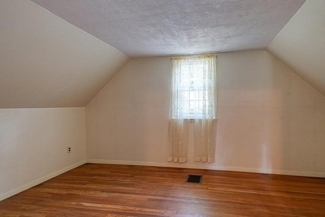 22 Willis Lake Dr, Sudbury, MA 01776 - additional living space featuring wood finished floors, lofted ceiling, and a textured ceiling