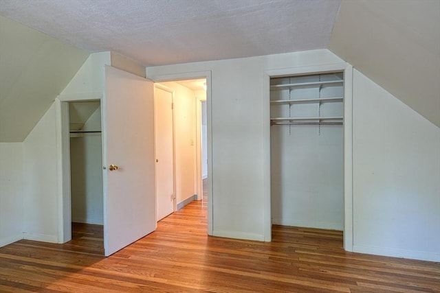 22 Willis Lake Dr, Sudbury, MA 01776 - unfurnished bedroom with wood finished floors, a textured ceiling, and vaulted ceiling