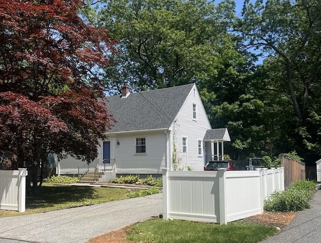 22 Willis Lake Dr, Sudbury, MA 01776 - view of home's exterior with a shingled roof and a chimney