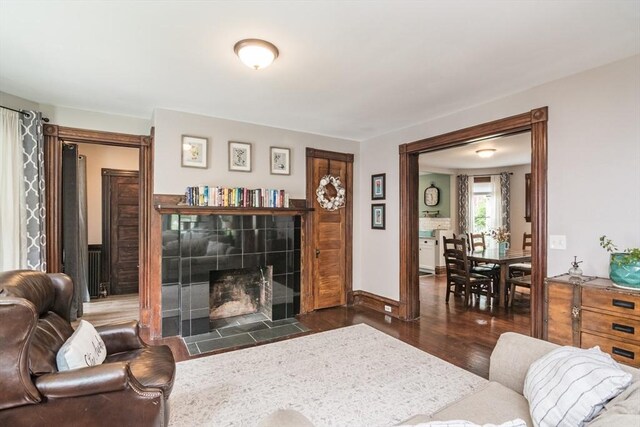 61 Fairfield Ave, Holyoke, MA 01040 - living room featuring dark wood-style flooring, a tiled fireplace, and baseboards