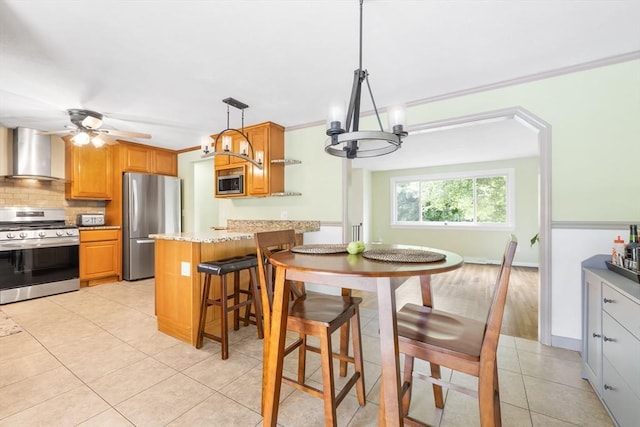 4 Charles River Rd, Medway, MA 02053 - kitchen featuring appliances with stainless steel finishes, wall chimney exhaust hood, tasteful backsplash, light tile patterned flooring, and a chandelier