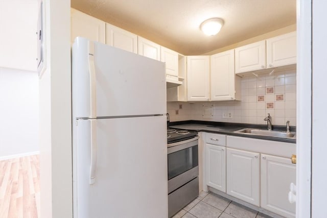 770 Cummins Hwy Unit 12, Boston, MA 02126 - kitchen featuring freestanding refrigerator, stainless steel range with electric stovetop, dark countertops, white cabinets, and tasteful backsplash