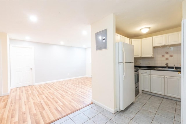 770 Cummins Hwy Unit 12, Boston, MA 02126 - kitchen with freestanding refrigerator, electric panel, open floor plan, dark countertops, and white cabinets