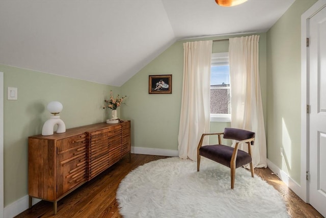 living area with vaulted ceiling, baseboards, and wood finished floors