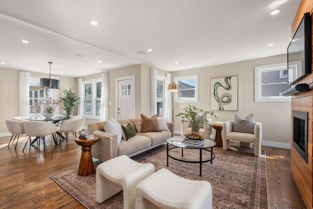 living room featuring recessed lighting, a fireplace, baseboards, and wood finished floors