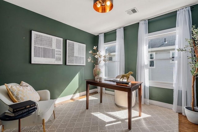 home office with visible vents, baseboards, and wood finished floors