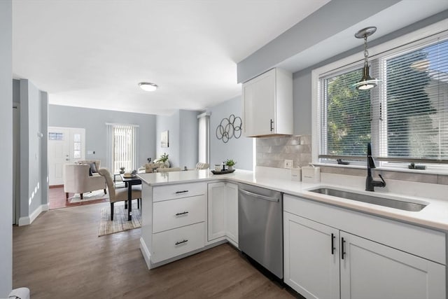 kitchen with kitchen peninsula, dishwasher, hanging light fixtures, white cabinetry, and sink