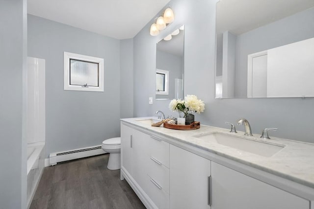 bathroom featuring toilet, a baseboard heating unit, hardwood / wood-style flooring, and vanity