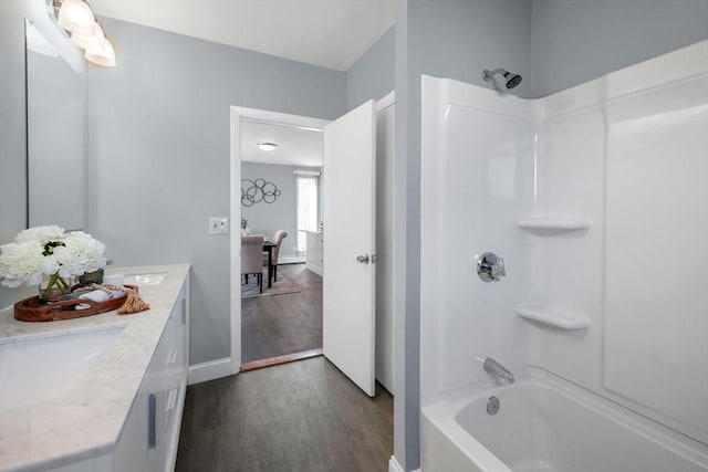 bathroom with hardwood / wood-style flooring, tub / shower combination, and vanity