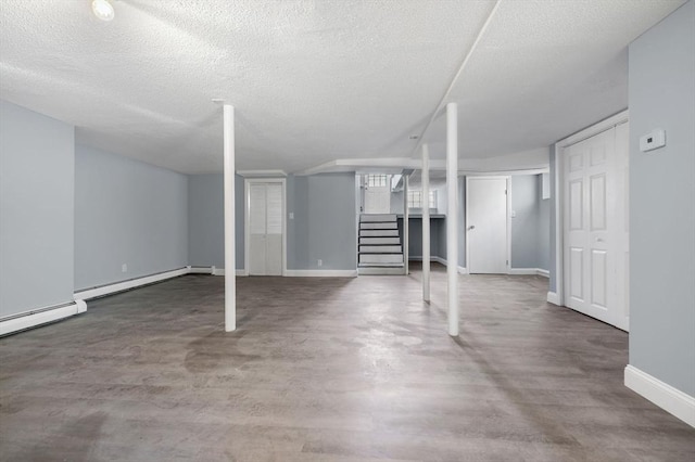 basement with a textured ceiling and baseboard heating