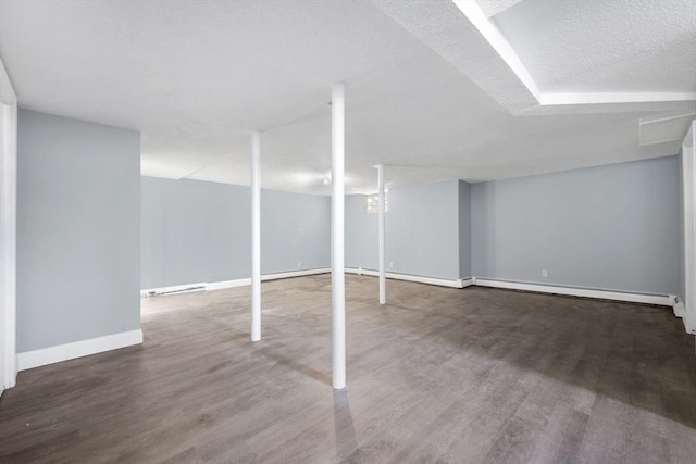 basement featuring a baseboard radiator and dark hardwood / wood-style floors