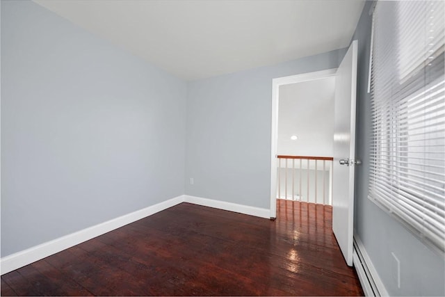 unfurnished room with a baseboard radiator and dark hardwood / wood-style floors