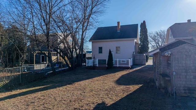 rear view of house with a storage unit and a deck