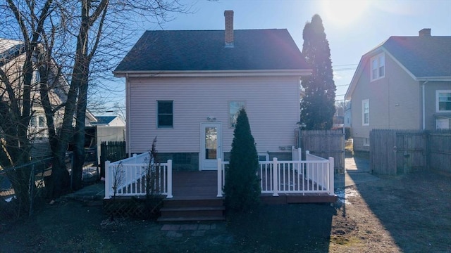 rear view of property featuring a wooden deck