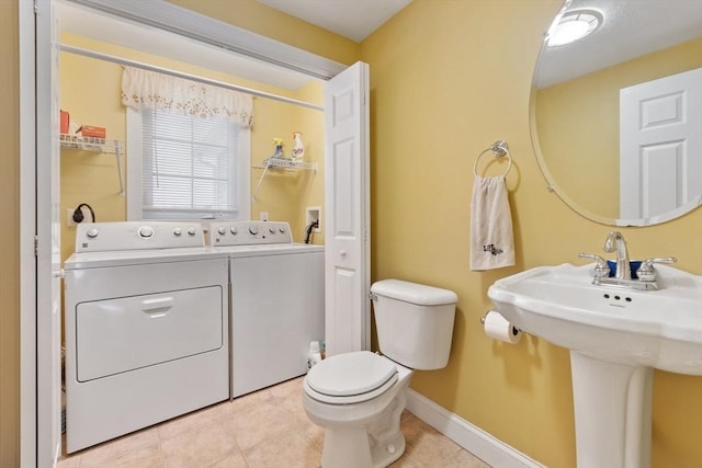 bathroom with baseboards, separate washer and dryer, toilet, and tile patterned flooring