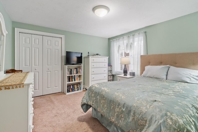 bedroom featuring a closet and light colored carpet